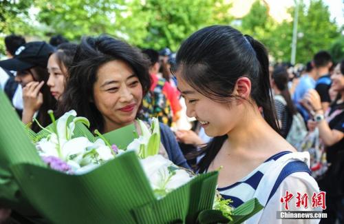 資料圖：山東濟南眾多考生手捧鮮花在家長的簇擁下歡快告別高考。中新社記者 張勇 攝