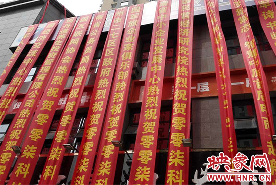 路邊一棟樓上懸掛著二三十條紅色條幅，全部是祝賀一家公司開業(yè)的。