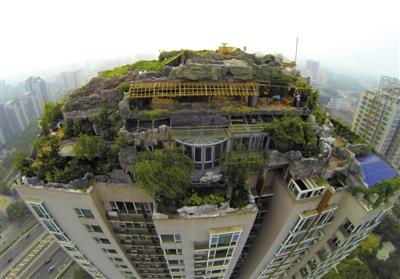 　　昨日，身穿橘黃色馬甲的工作人員在人濟山莊樓頂拆除違章建筑。新京報記者 吳江 攝