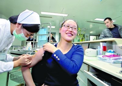 昨日，向雪敏在同濟醫(yī)院血液科病房打動員劑，丈夫陳武右在身后注視著妻子 記者傅克強