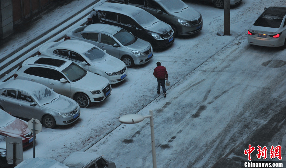 11月18日，行人在沈陽街頭的積雪中穿行。