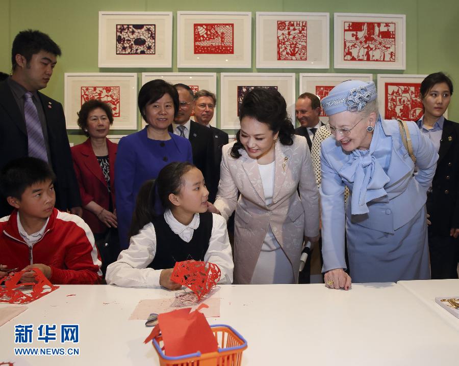 這是彭麗媛和瑪格麗特二世與根據(jù)安徒生童話中人物和情節(jié)制作剪紙的孩子交談。