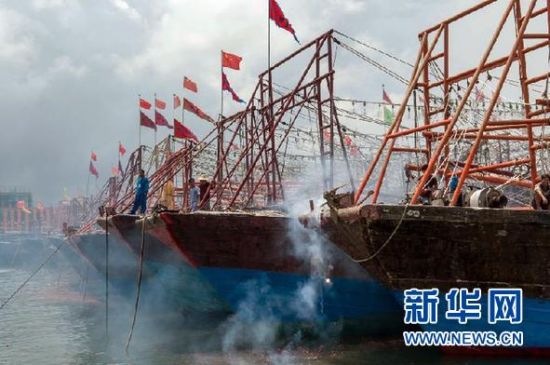 2013年8月1日 南海開漁日 臨高迎新港 8月1日，海南省臨高縣漁民在船上鳴放鞭炮慶祝武蓮港開港。