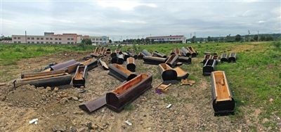 40多副棺木被砸壞后，扔在荒地上。