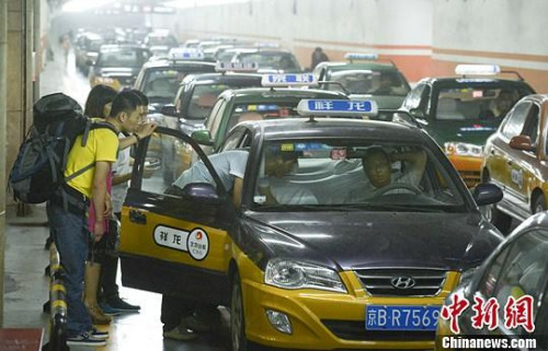 市民在北京西客站出租車候車點(diǎn)準(zhǔn)備乘車。中新社發(fā) 侯宇 攝