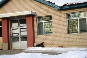 伊春市帶嶺區一排破舊的平房，房間窗戶上貼滿了“我告饒了”的字樣。
