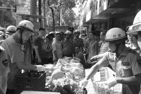 7月11日，瀏陽(yáng)市北正中路，執(zhí)法人員暫扣張海的水果。這是瀏陽(yáng)市城管局拍攝的執(zhí)法現(xiàn)場(chǎng)圖。