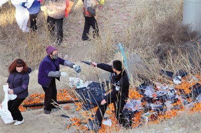 1月4日，連霍高速蘭州市榆中縣和平鎮段，一名警察舉著槍驅散哄搶橘子的村民。圖/CFP