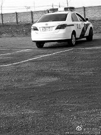 一輛車牌號 為“ 陜DD173”的制式警車停在一個劃著白線的場地上，車身標有“司法”字樣