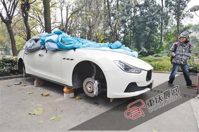 昨日，停放在重慶大學B區的一輛瑪莎拉蒂豪車被架在幾塊磚頭上，車輪不翼而飛。 重慶晨報記者 胡杰 攝