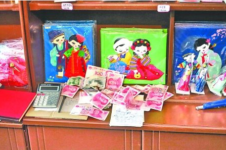 　　2012年6月21日，在朝鮮羅先特別市的一家商店里，柜臺上散落著一些人民幣。在朝鮮，人民幣比本國