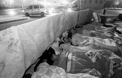 在寒冷的冬夜，為了能省點錢，方便接活，民工們仍睡在橋下。