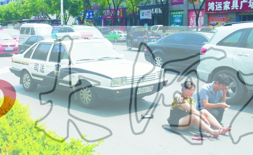 事故發(fā)生后，警車司機(jī)（右）下車查看傷者并撥打120，倆“領(lǐng)導(dǎo)”穩(wěn)坐車內(nèi)引發(fā)圍觀者不滿。