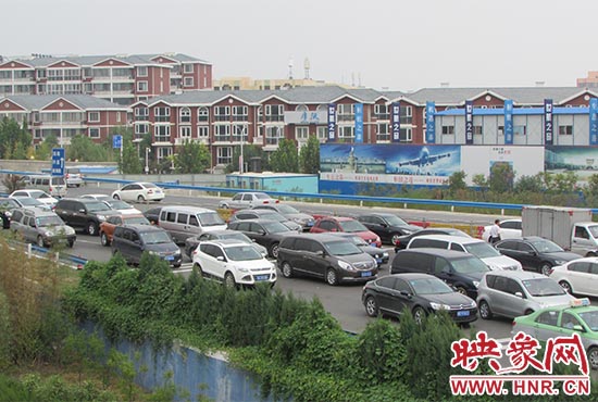 記者看到鄭州機場收費站口車輛排隊，與此形成鮮明對比的是，路的對面（另一半幅）卻車輛較少，通行順暢。