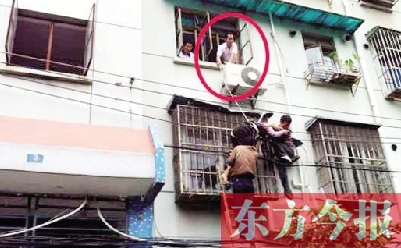 施救現場，劉鵬（圈內）先用繩子捆住老太確保安全 勞動報記者 郭娜 供圖