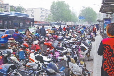 省人民醫(yī)院北門，路邊的公交站牌處停滿非機(jī)動(dòng)車，上、下客只能在快車道上。