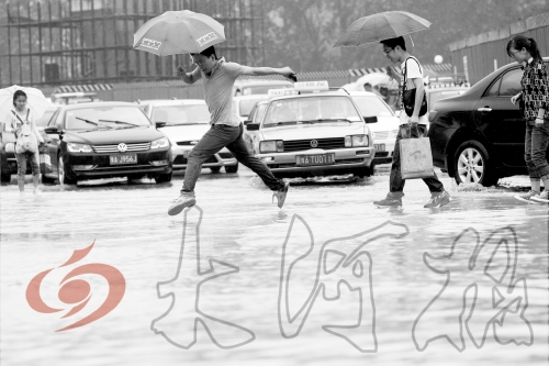 鄭州經三路與北環交叉口處，積水較深，行人們不得不“練輕功”。 記者 白周峰 攝影