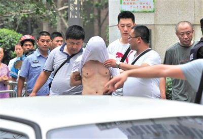 昨日，成都警方抓捕時與毒犯發(fā)生槍戰(zhàn)。一名男犯罪嫌疑人被警方押出。