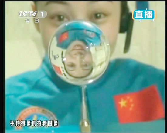 王亞平的倒影出現在水球中。新華社發（視頻截圖）