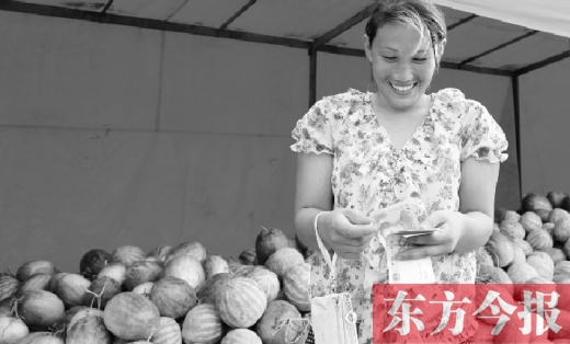 昨日，開封瓜農(nóng)史瑩瑩幸福地?cái)?shù)著賣瓜錢 東方今報(bào)記者 沈翔 攝