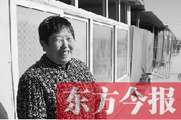 在京水村的臨時過渡區內，一位大媽在儲存大白菜