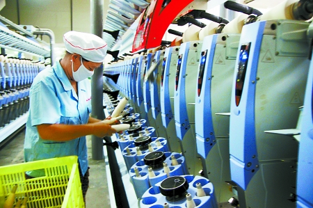 7月3日，在鄧州市永泰棉紡有限公司電腦控制全自動紡紗車間，紡織工人正在生產棉紗。