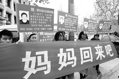 張慧媛老人的子女們舉著尋找母親的牌子和橫幅，在冷風中呼喊著“媽媽，您快回來吧”。