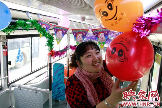 鄭州快速公交B3區(qū)間線車長李鵬云在車廂里懸掛氣球，布置圣誕車廂，營造歡樂圣誕氛圍