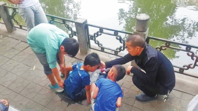 男孩被救出后，圍觀群眾幫他控水換衣服。
