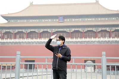 11月1日，北京大部分地區(qū)重度污染，一名游客戴著口罩在午門前揮手跟朋友打招呼。 實(shí)習(xí)生 王飛 攝