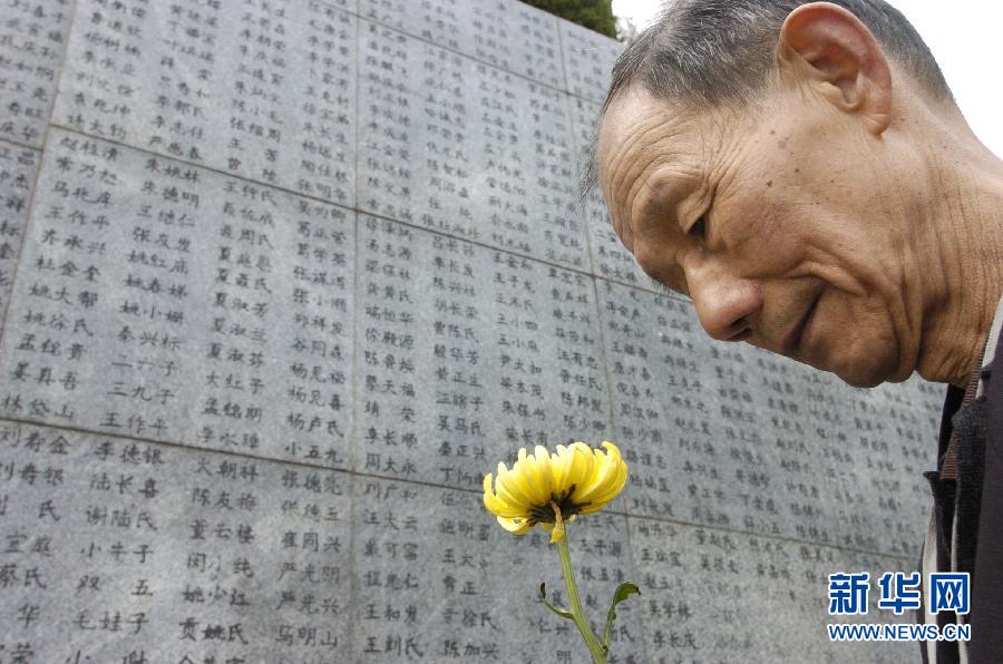 2006年4月5日，74歲的南京大屠殺幸存者佘子清手捧鮮花，祭奠被日軍殺害的母親。