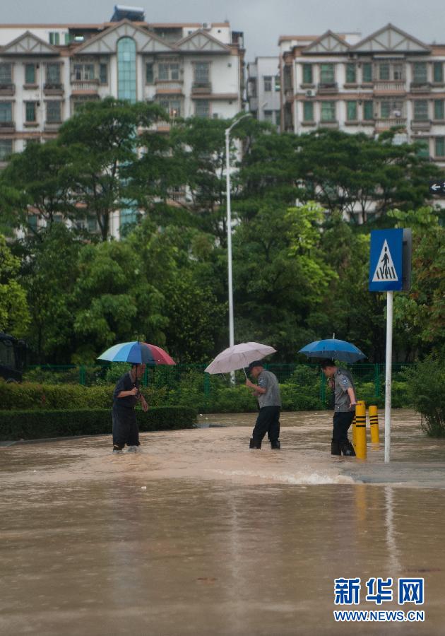 5月11日，人們在深圳西麗涉水行走。