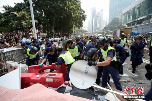 10月14日，警方清除金鐘道障礙物。大批警員在金鐘道現(xiàn)場清拆障礙物。部分警員戴上頭盔將障礙物移走。