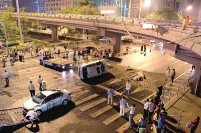 路虎沖下國貿橋砸中一輛起亞轎車，橋上厚達幾十厘米的水泥護欄被撞斷，碎石四處散落，數十群眾在現場圍觀。