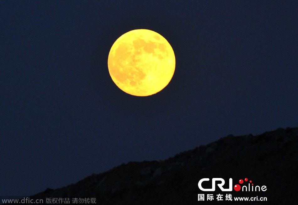8月10日晚，一輪金燦燦的大月亮在遼寧省大連市東方升起。圖片來源：劉德斌/東方IC