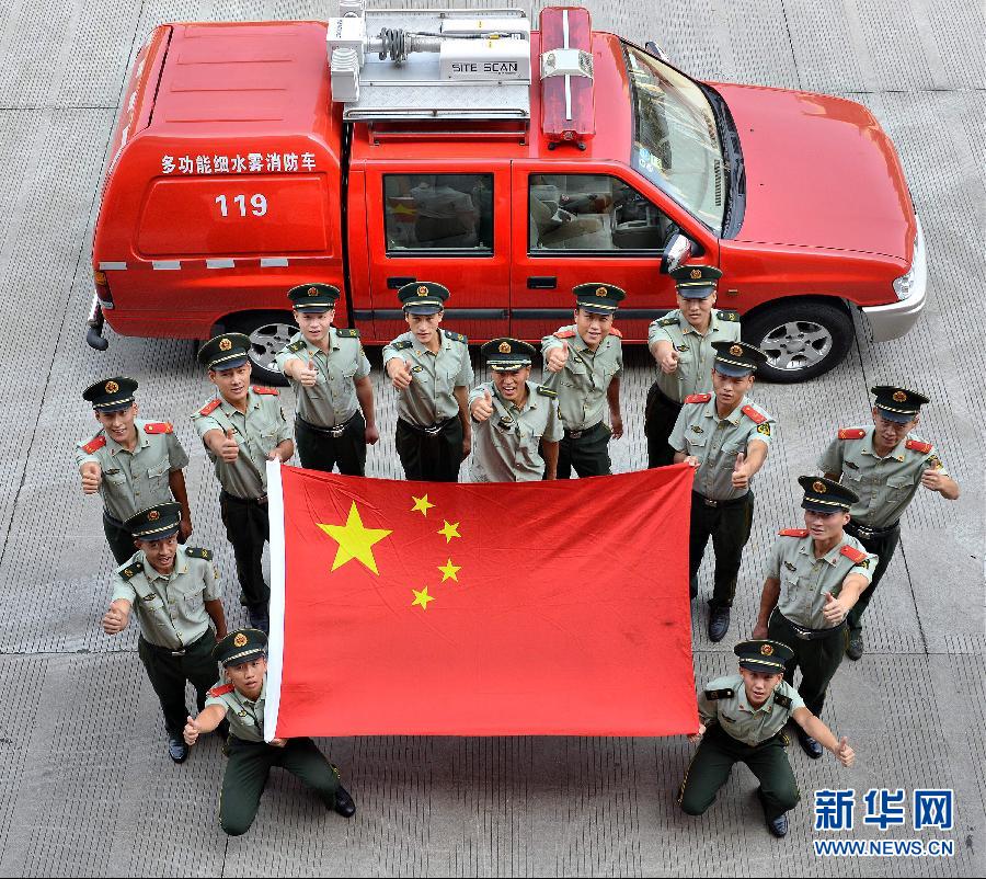  9月25日，武警浙江嘉興消防官兵與國旗合影。