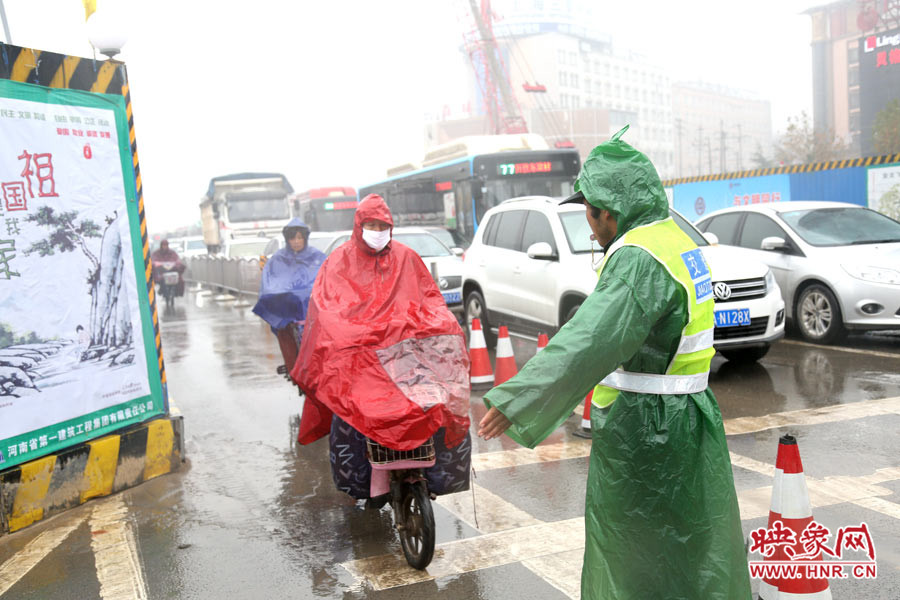交通協管員下雨天堅守崗位，疏導交通。