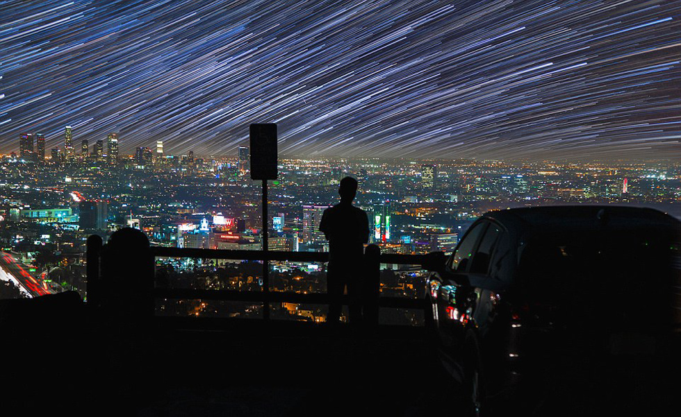照片中，一名男子看著流星和隕星劃過天空。（網(wǎng)頁截圖）