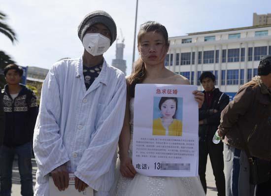 昆明火車站廣場上，24歲的黃習菊身穿潔白的婚紗，帶著身患白血病的弟弟征婚。