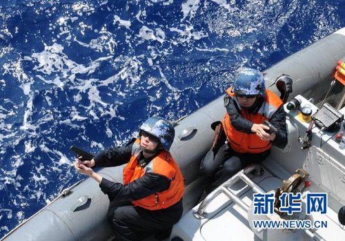 　3月28日，十余名臨檢拿捕隊員乘小艇駛至模擬可疑商船下方水面。